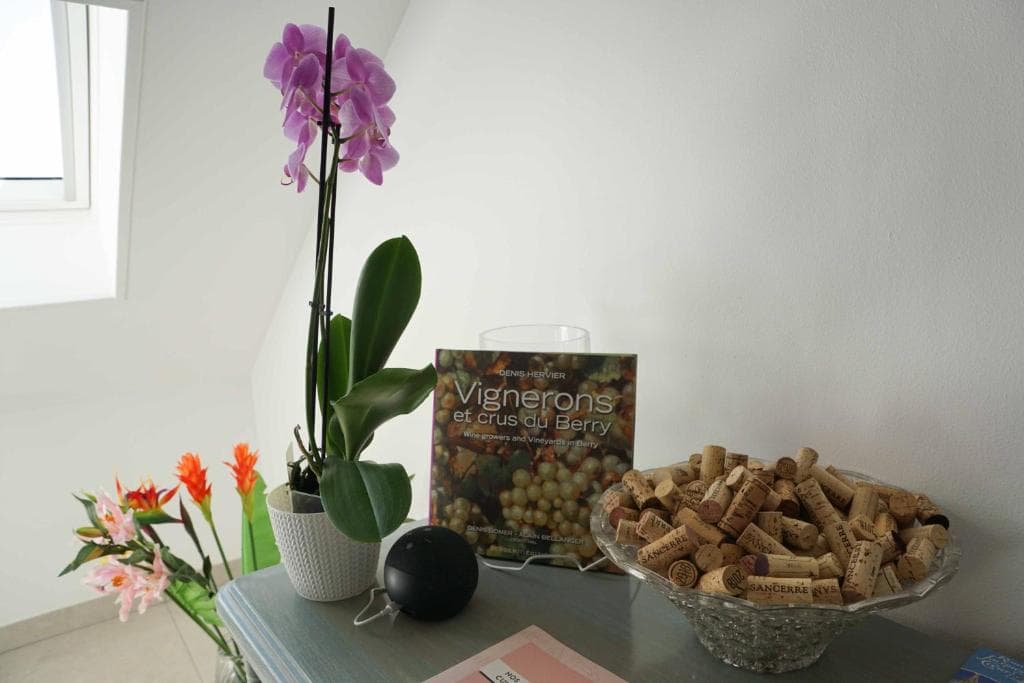 Détail d'accueil — orchidée, livre Vignerons et crus du Berry, bol de bouchons