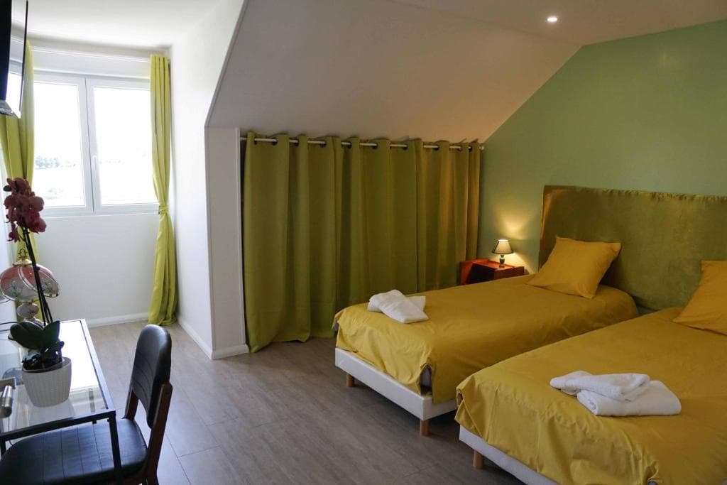Chambre mansardée avec deux lits simples sous combles